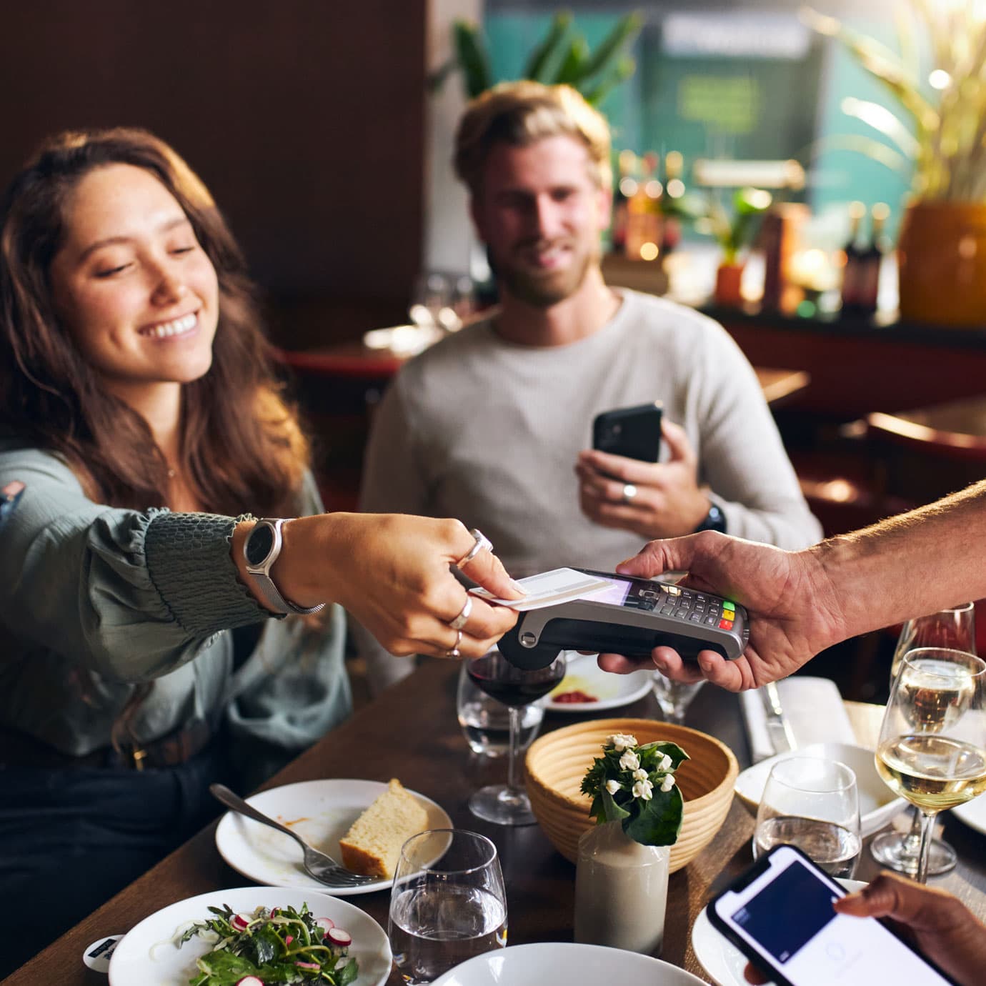 Multiple people paying at a restaurant