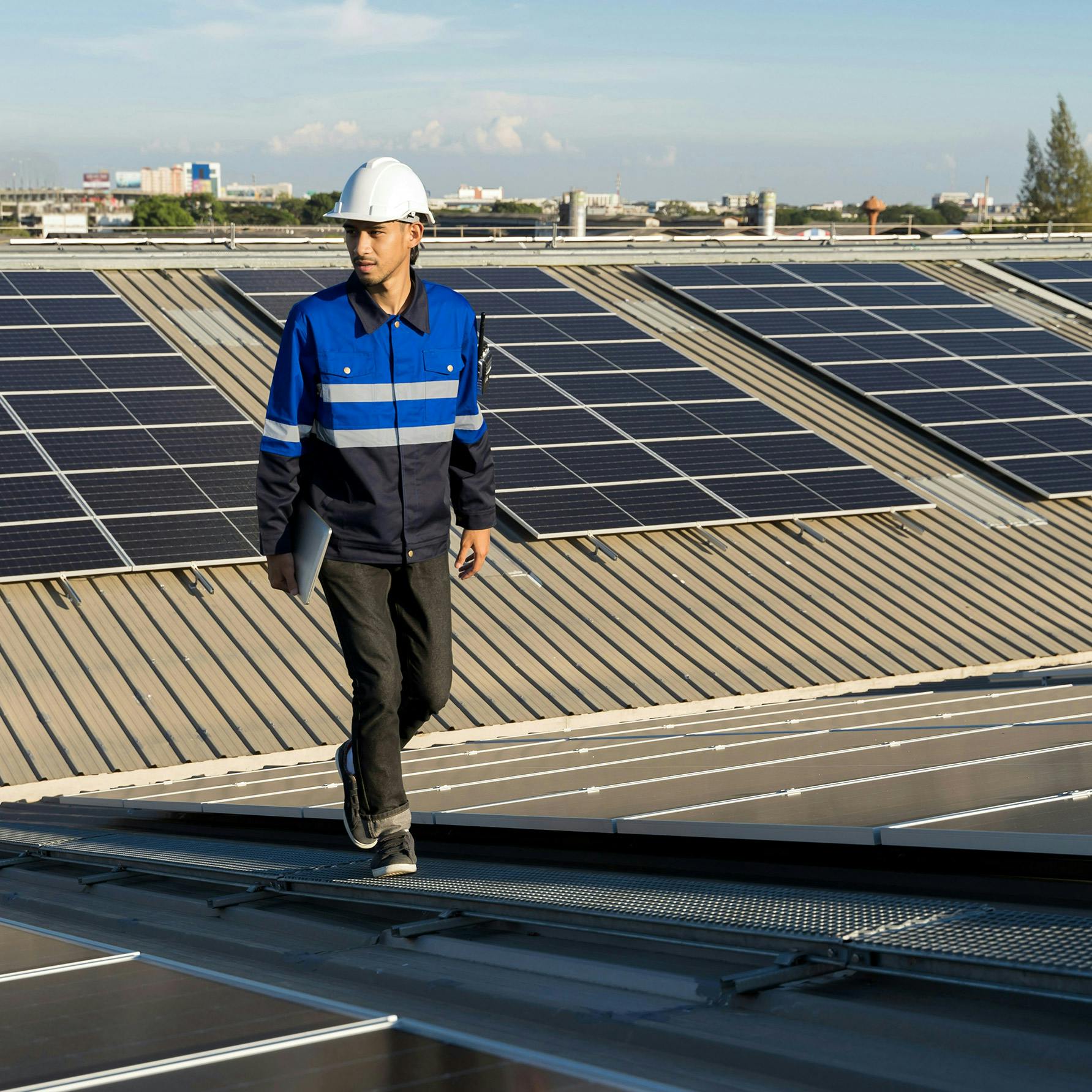 Solar installer walking across roof with panels