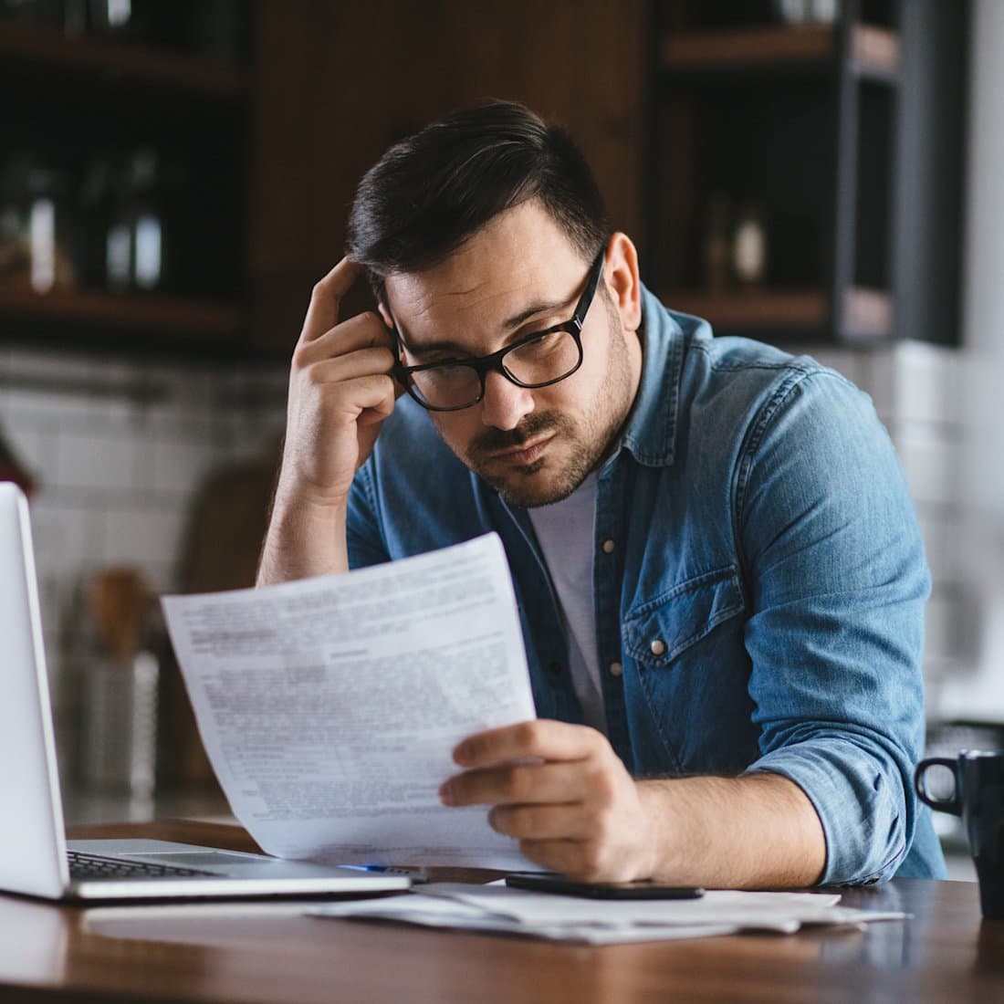 Business owner reviewing a water bill at a laptop